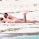 Travis Kelce naps in the Bahamas sun with Taylor Swift and places hand on her booty to know she is still there